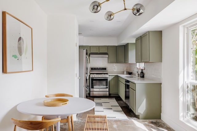 kitchen with appliances with stainless steel finishes, sink, green cabinets, and tasteful backsplash