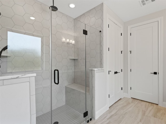 bathroom with an enclosed shower, vanity, and tile patterned floors