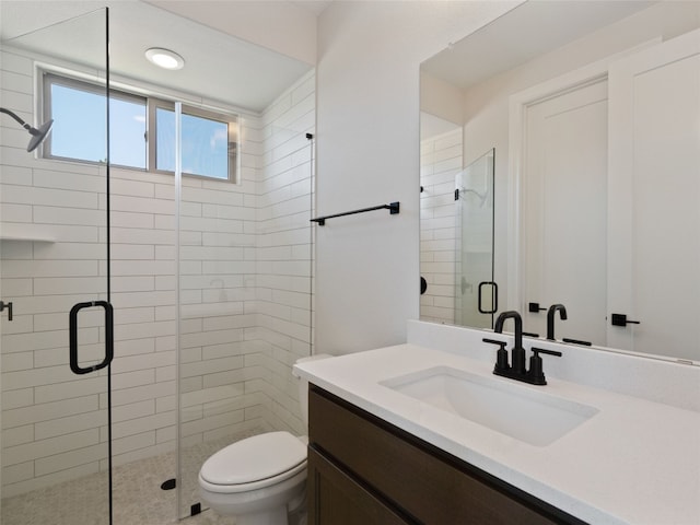 bathroom with a shower with door, vanity, and toilet