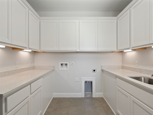 clothes washing area featuring electric dryer hookup, washer hookup, cabinets, dark tile patterned floors, and hookup for a gas dryer