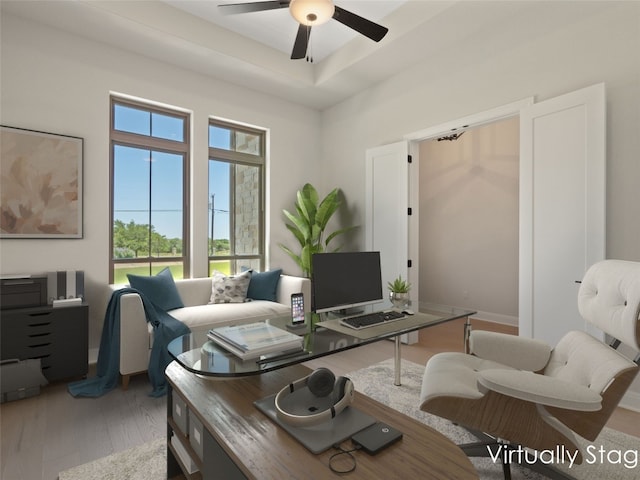 living room with ceiling fan, a raised ceiling, and hardwood / wood-style flooring