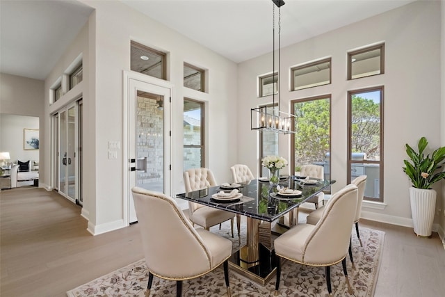 dining space featuring light hardwood / wood-style flooring and an inviting chandelier