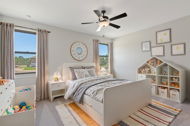 bedroom with ceiling fan and light carpet