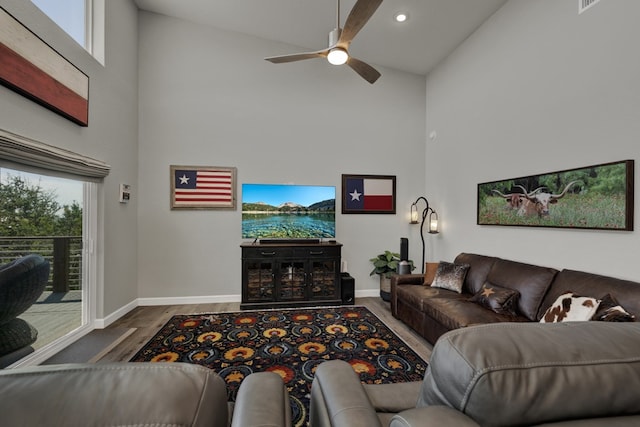 living room featuring hardwood / wood-style floors, high vaulted ceiling, and ceiling fan