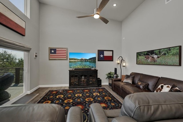 living area featuring wood finished floors, ceiling fan, high vaulted ceiling, and a wealth of natural light