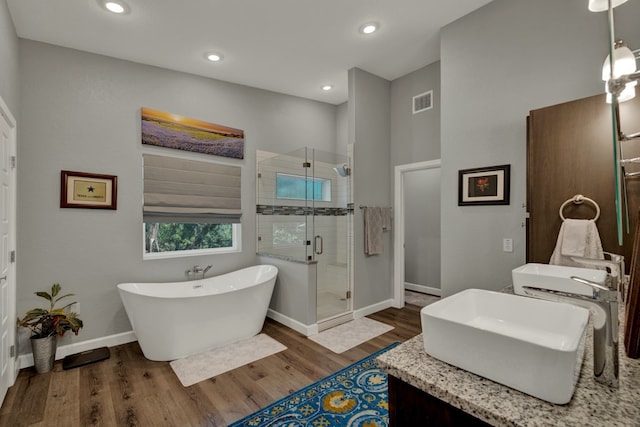 bathroom featuring wood-type flooring, vanity, and separate shower and tub