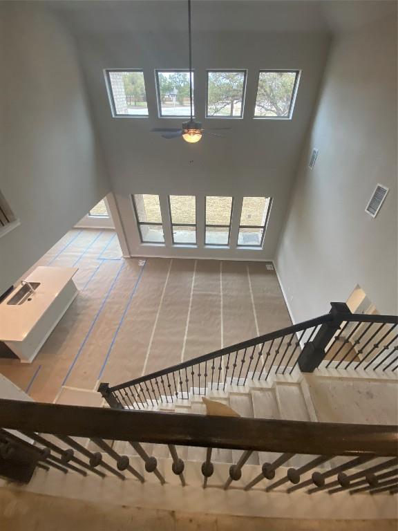 stairs with a healthy amount of sunlight and ceiling fan