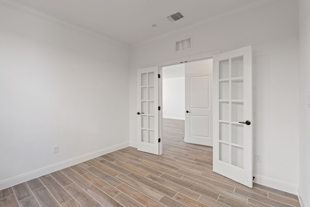 unfurnished room with crown molding, french doors, and light hardwood / wood-style flooring