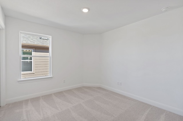 spare room featuring light colored carpet