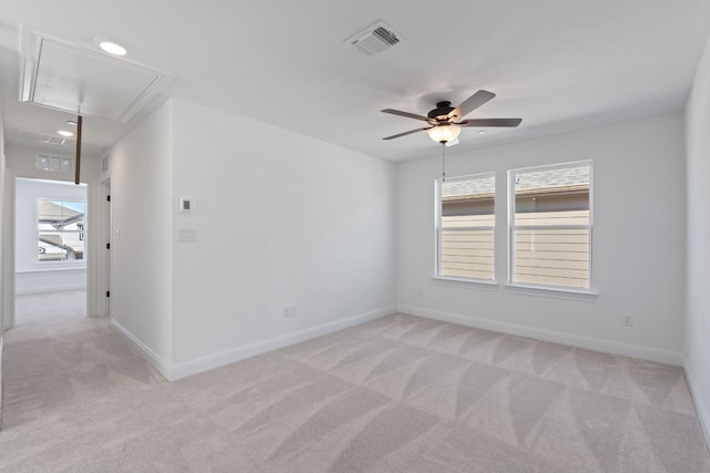 empty room with a wealth of natural light, light colored carpet, and ceiling fan