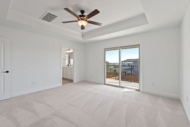 unfurnished room with a tray ceiling, crown molding, ceiling fan, and light colored carpet