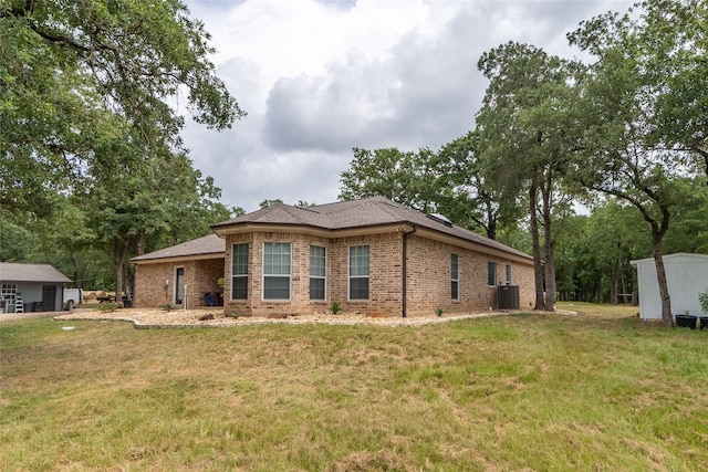 view of front of house with a storage shed and a front yard