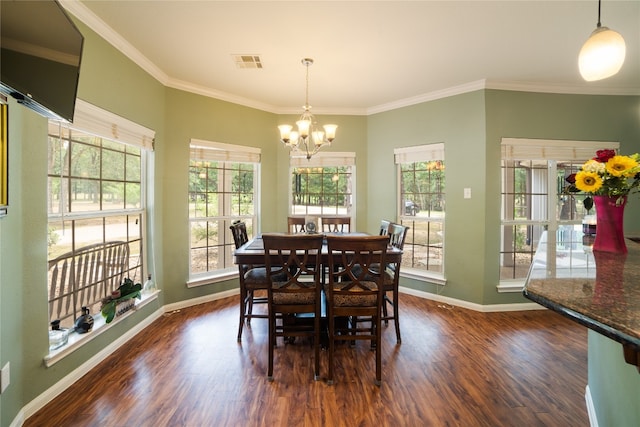 dining space featuring dark hardwood / wood-style flooring, crown molding, and a chandelier