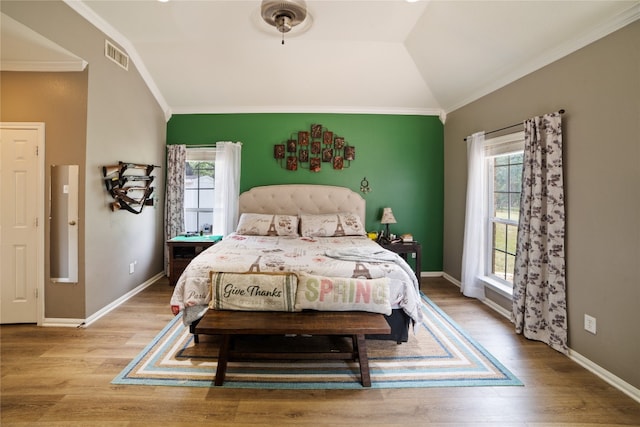 bedroom featuring light hardwood / wood-style flooring, lofted ceiling, and crown molding