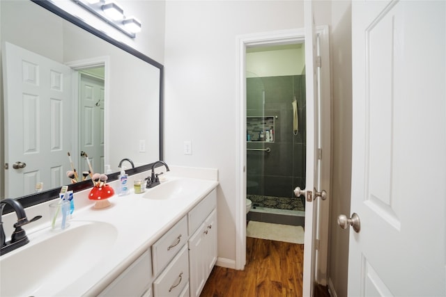 bathroom with hardwood / wood-style flooring, an enclosed shower, vanity, and toilet