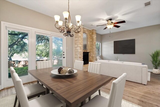 dining area featuring light wood-type flooring and ceiling fan with notable chandelier