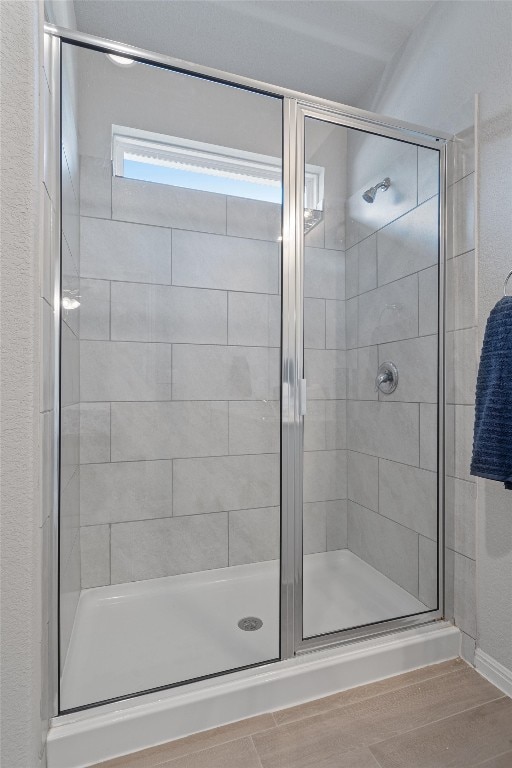 bathroom featuring an enclosed shower and hardwood / wood-style flooring