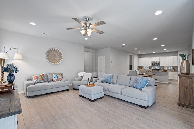 living room with ceiling fan and light hardwood / wood-style floors