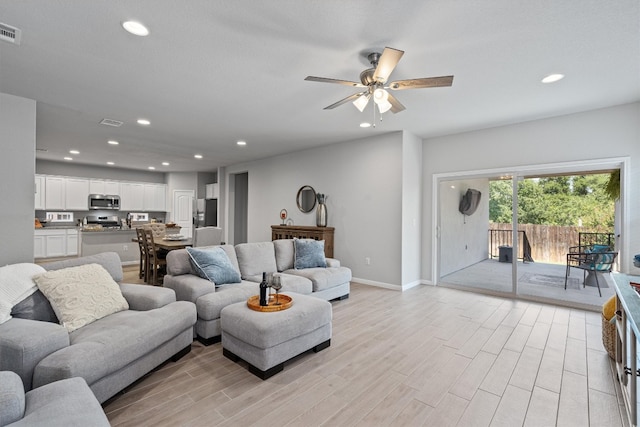 living room featuring ceiling fan and light hardwood / wood-style floors