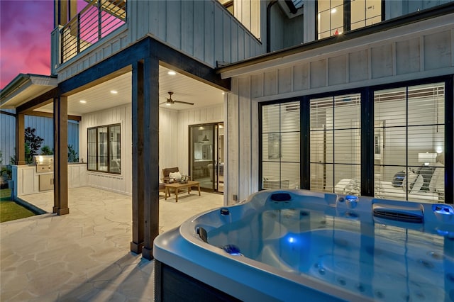 exterior space featuring ceiling fan, a tub, and wood walls