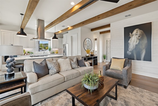 living room with light hardwood / wood-style flooring and beamed ceiling