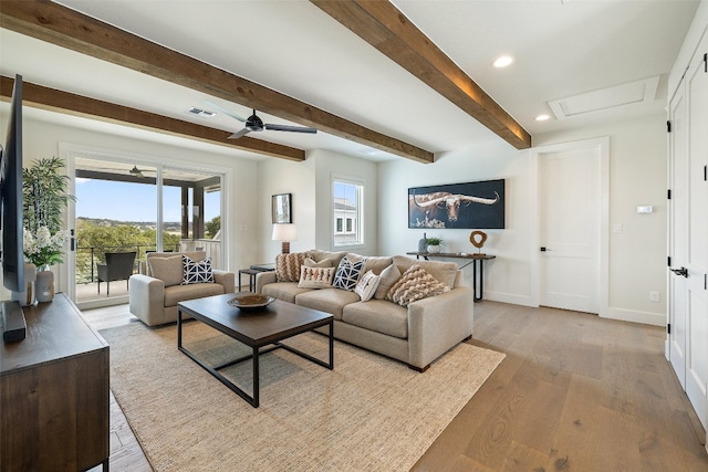 living room with light hardwood / wood-style flooring, ceiling fan, and beamed ceiling