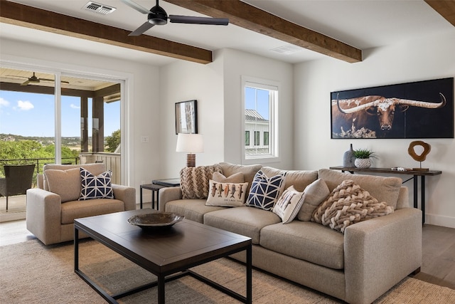 living room featuring ceiling fan, beamed ceiling, and light hardwood / wood-style floors