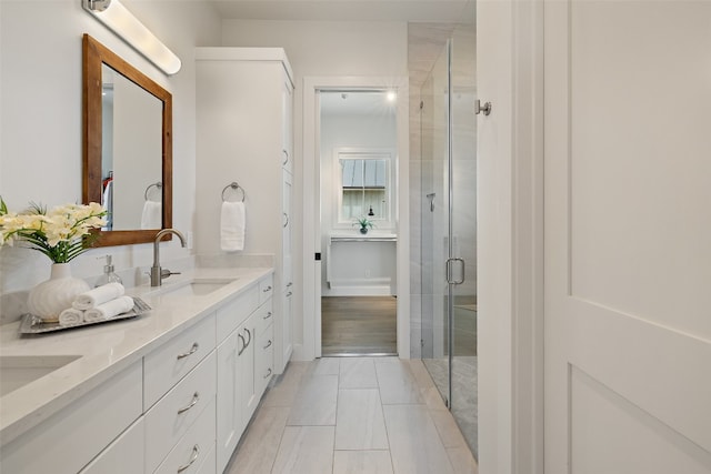 bathroom featuring tile patterned flooring, vanity, and a shower with shower door