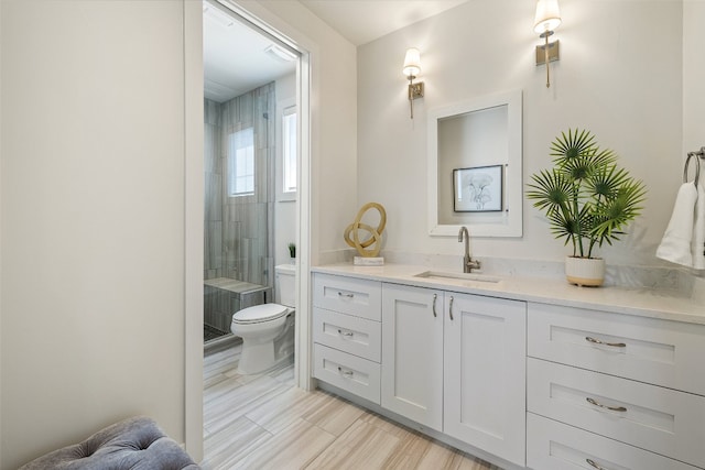 bathroom featuring tile patterned floors, toilet, vanity, and a shower with shower door