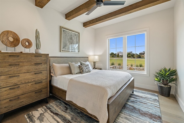 bedroom featuring ceiling fan, beam ceiling, and dark hardwood / wood-style floors