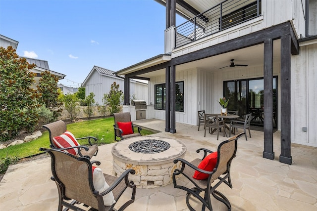 view of patio with a fire pit, exterior kitchen, a balcony, ceiling fan, and a grill