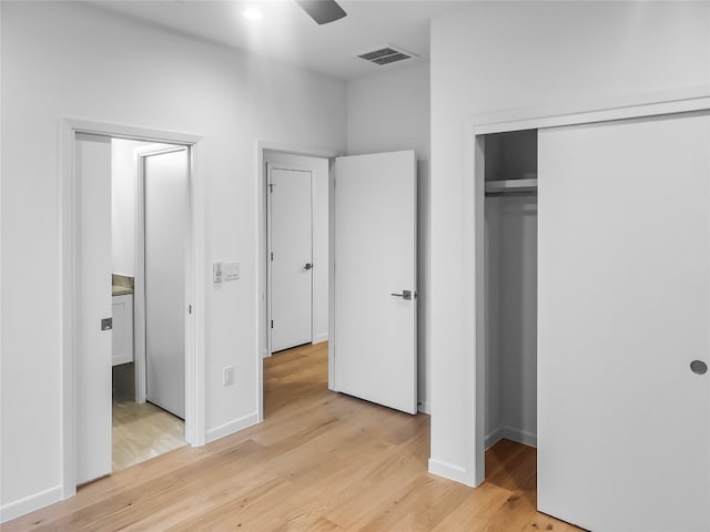 unfurnished bedroom with a closet, ceiling fan, and light wood-type flooring