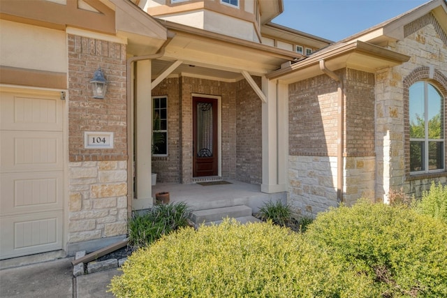 view of exterior entry featuring covered porch and a garage