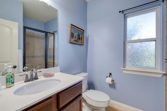 bathroom featuring a shower with shower door, vanity, and toilet