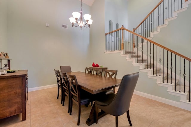 dining room with light tile patterned floors, a high ceiling, and a chandelier