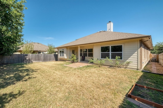 rear view of property with cooling unit and a yard