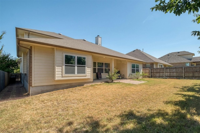 back of house featuring a lawn