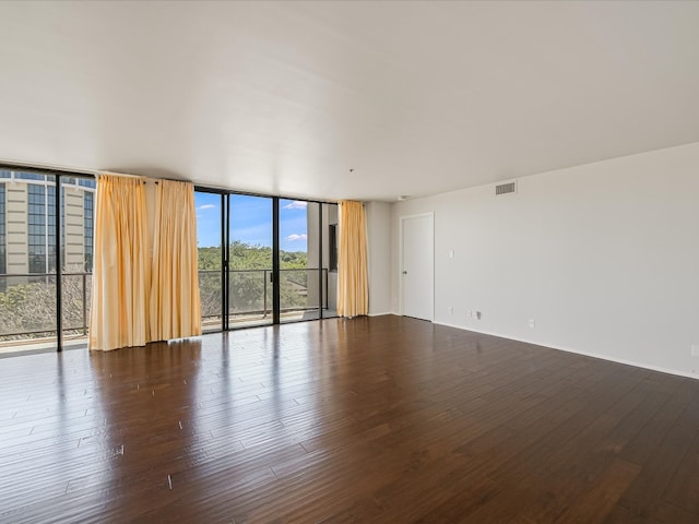 unfurnished room featuring expansive windows and wood-type flooring