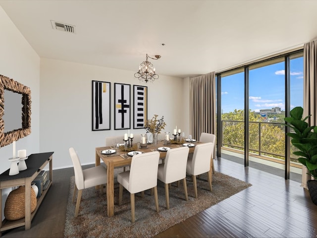 dining space with dark hardwood / wood-style flooring, expansive windows, and a chandelier