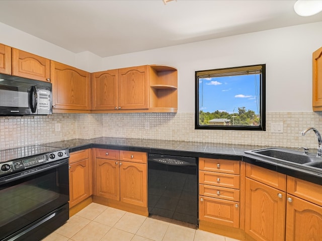 kitchen with sink, tasteful backsplash, black appliances, and light tile patterned flooring