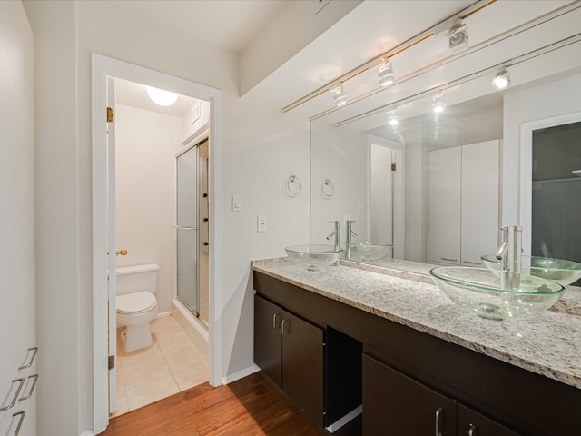 bathroom with toilet, hardwood / wood-style floors, vanity, and walk in shower