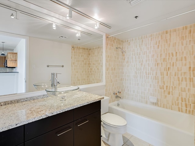 full bathroom with tile patterned floors, toilet, vanity, and tiled shower / bath