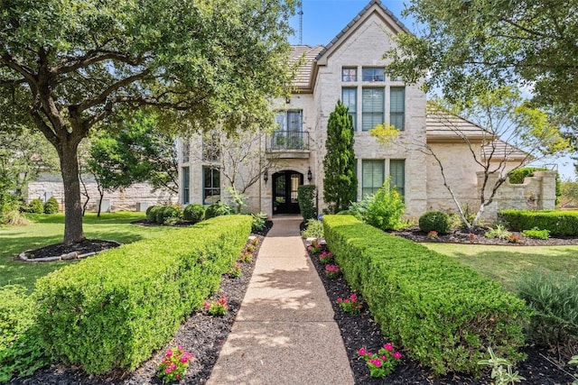 view of front facade featuring stucco siding, a tile roof, and a front yard