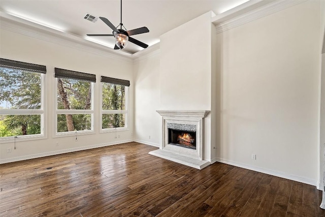 unfurnished living room with dark wood-style floors, visible vents, ornamental molding, a warm lit fireplace, and baseboards