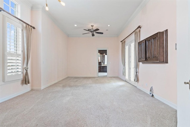 empty room featuring baseboards, a ceiling fan, light colored carpet, crown molding, and recessed lighting