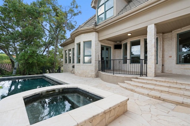 outdoor pool featuring a patio and an in ground hot tub