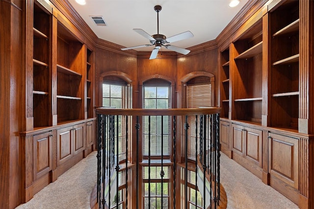 hallway featuring visible vents, carpet, a wealth of natural light, and crown molding