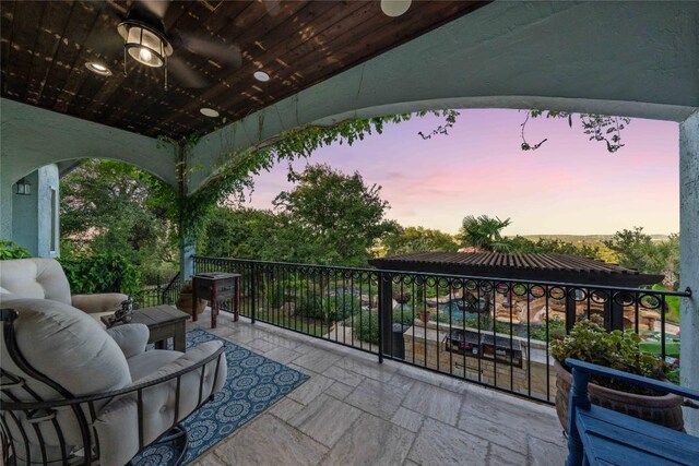 patio terrace at dusk with a balcony and an outdoor hangout area