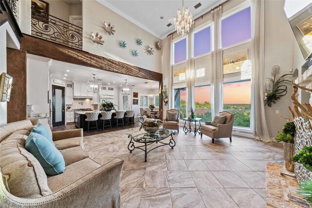 living room with light tile patterned floors, ceiling fan with notable chandelier, crown molding, and a high ceiling