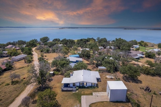 aerial view at dusk featuring a water view